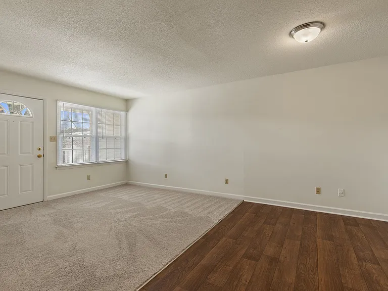 Shamrock living room with hardwood flooring and bright, expansive windows