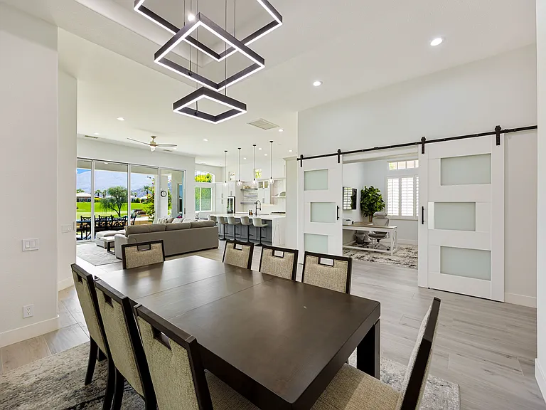 The dining area features a stunning pendant chandelier and seating for eight!
