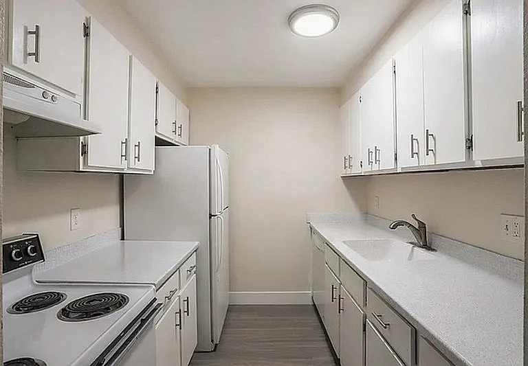 Bright and modern kitchen with sleek white cabinetry, ample counter space, and contemporary appliances.