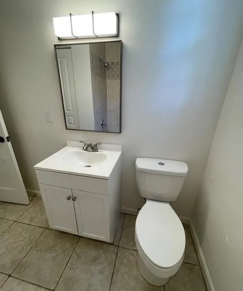 Toilet and vanity with new mirror and light fixture.