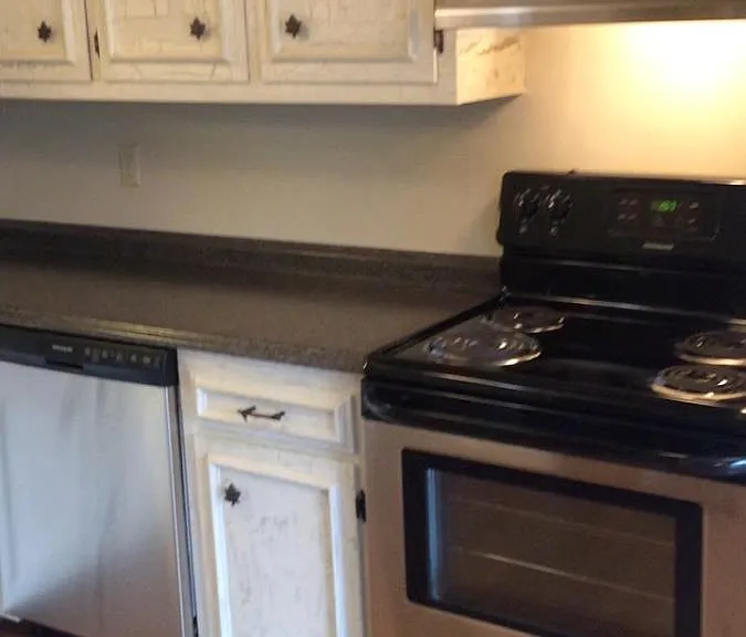 Antiqued cabinets with custom built-ins, updated lighting an
