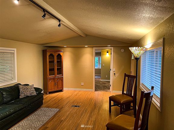 Living room from other side looking into Primary bedroom and ensuite bath.  Front entry is to the right.>