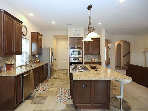 kitchen featuring built-in microwave and oven, island with 5 burner gas range