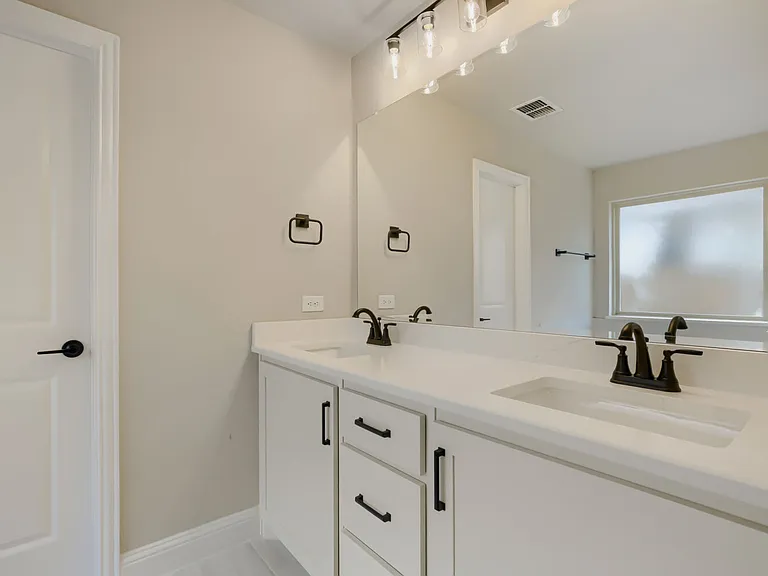 Dual vanity with integrated sinks, white countertops, and matte black fixtures