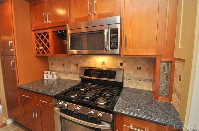 New kitchen installed in 2012, Granite counters, stainless steel appliances included a dishwasher, microwave, range and French door refrigerator, Custom Cherry cabinets with pantry, wine rack and crown molding, decorative tumbled tile backsplash.