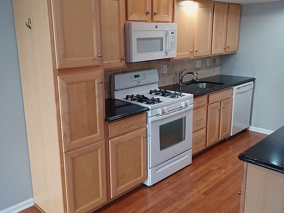 Large pantry cabinet, gas range, microwave, garbage disposal, and dishwasher