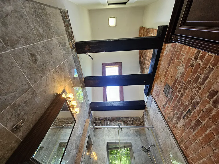 Super high vaulted ceiling with a skylight and there are those exposed wooden beams again.
