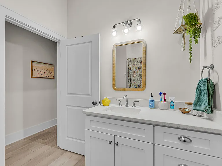 Second bathroom provides a single vanity with plenty of storage + a shower/tub combo