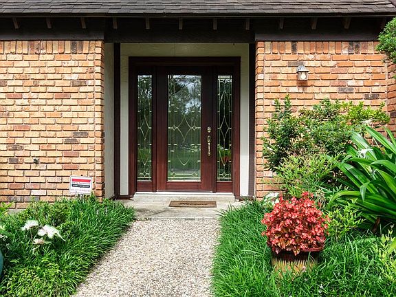 A covered entry leads to the wood and leaded-glass front door.