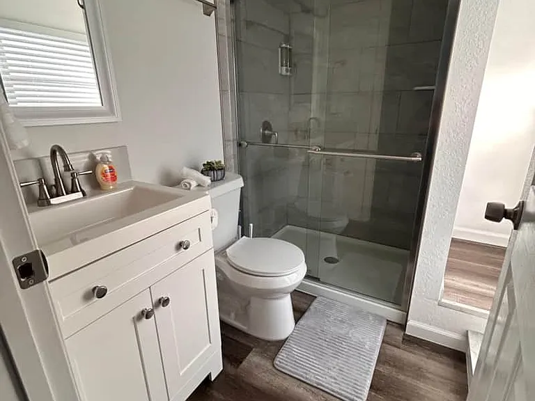 Comfortable bathroom with lighting, rugs, towels and racks