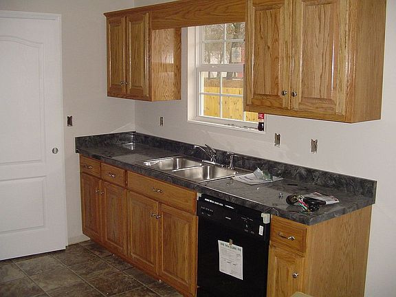 The kitchen is equipped with beautifully finished hardwood cabinetry.