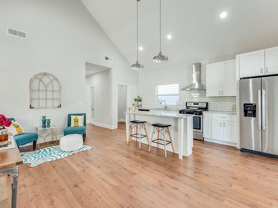 Living room and open kitchen with cathedral ceilings.