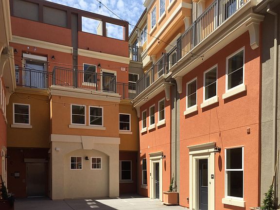 Colorful individual townhomes wrapped around a sunny, Mediterranean Courtyard