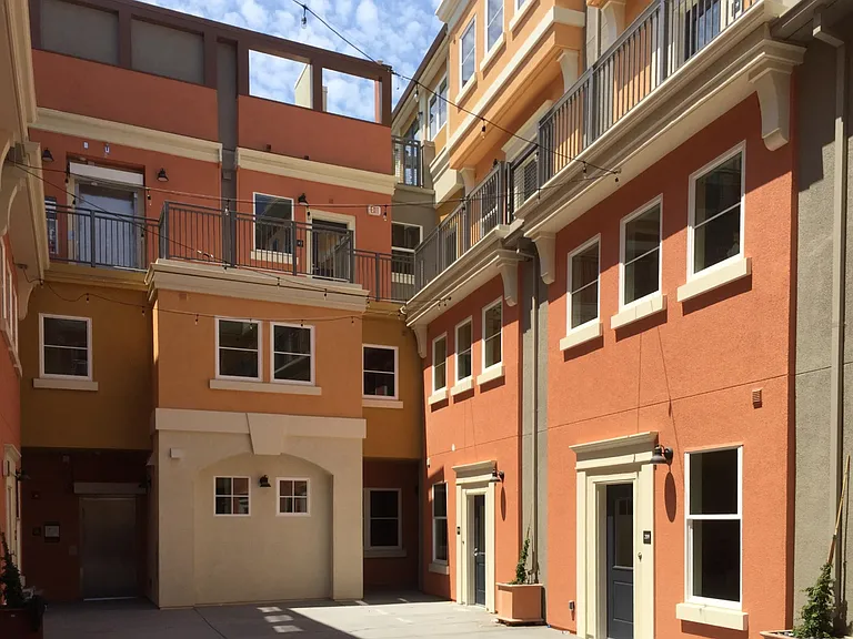 Colorful individual town homes wrapped around a sunny, Mediterranean Courtyard