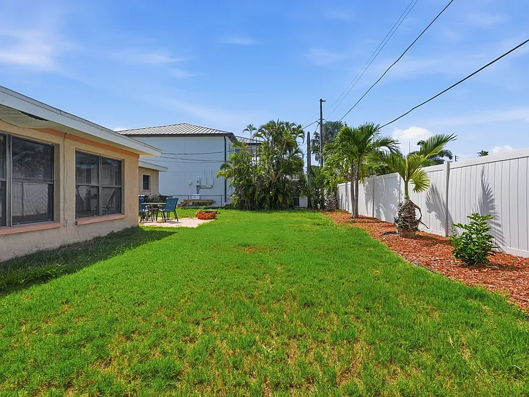 Fenced backyard includes patio off kitchen with gas grill, table/chairs and fire pit.