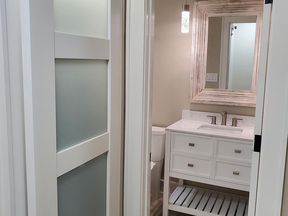 lighted linen closet in the hall with sliding custom barn door.