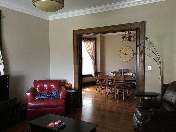Large living room with hardwood oak floors, crown moulding, and plenty of natural light.