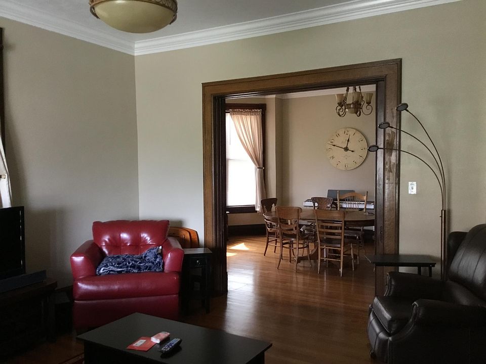 Large living room with hardwood oak floors, crown moulding, and plenty of natural light.