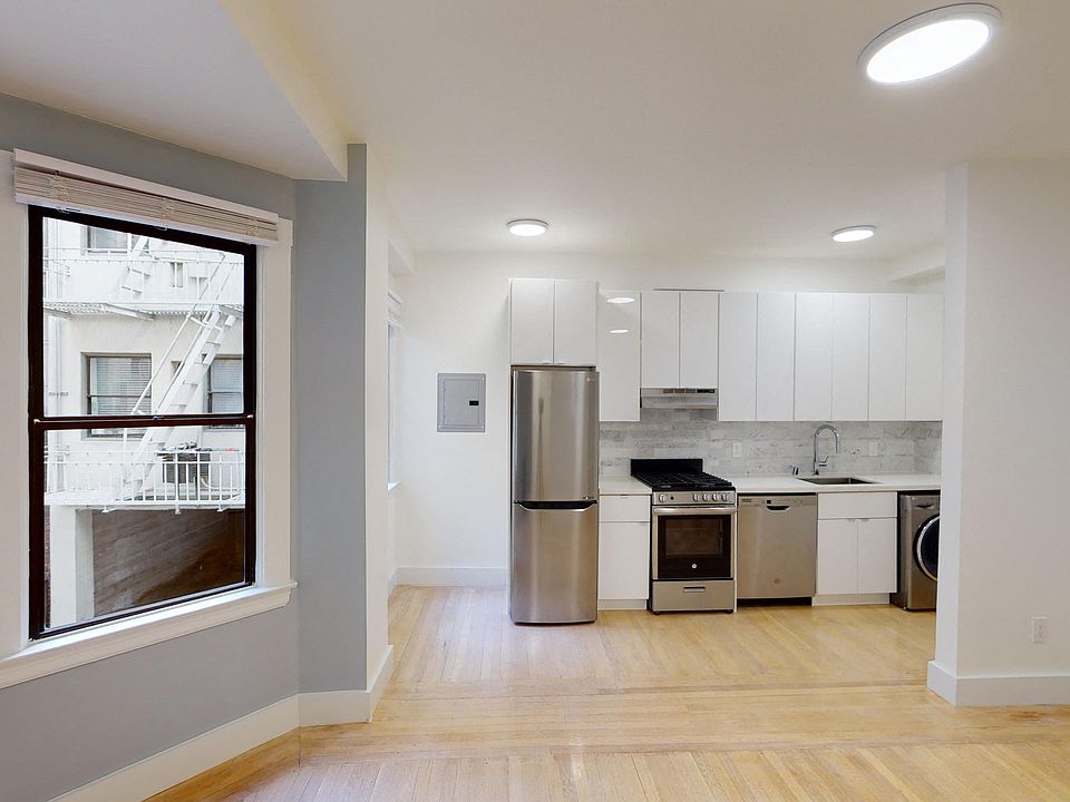 Living area that features cabinets, refrigerator, stove, range hood, and sink