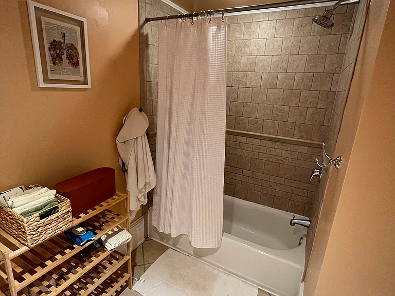 Bath/shower with storage space in the bath/toilet room. Italian tiled bath and floor. Standard sized ceiling in here.