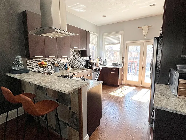 The beautiful kitchen features stainless steel appliances and a gas range.