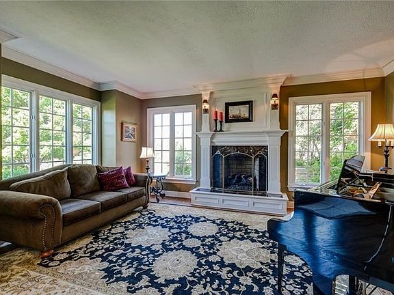 Classic design is evident in the formal living room with its large crown molding, beautiful fireplace wrapped in hand crafted mi