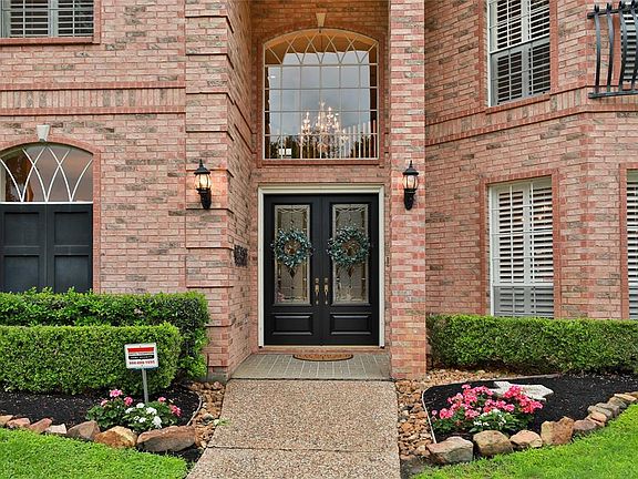 IT'S ALL IN THE DETAILS: Offset brick work, a two story entry porch, and arched windows accented by keystones all contribute to the striking exterior of this home, complimented by pretty landscaping.