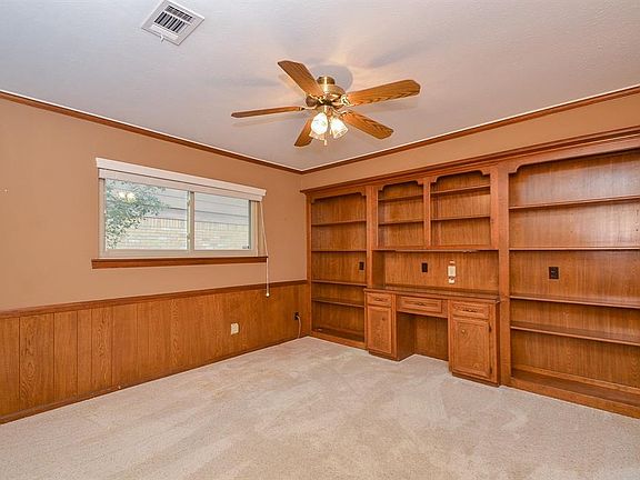 Spacious office/library with built-in desk area and shelves for all your books and photos.