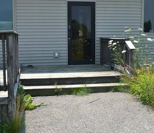 Entrance from the rear of the building.  The deck is off to one side and a patio walkway is directly off the back entrance.