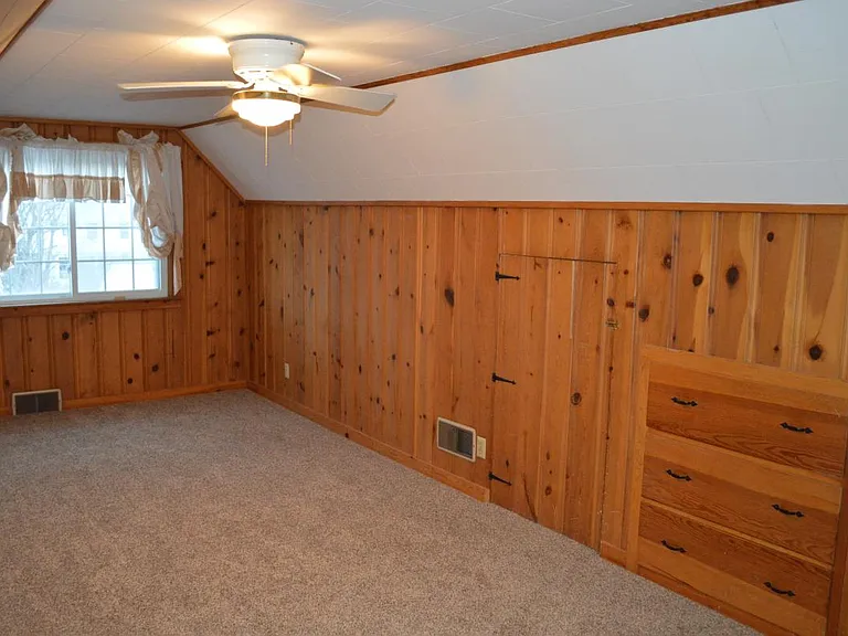 Large upstairs bedroom with knotty pine and dresser build-in