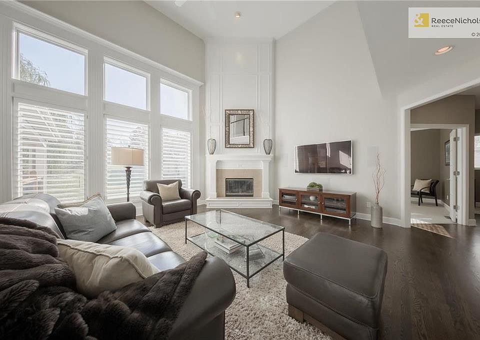 Two story great room with gorgeous hardwood floors, plantation shutters and corner fireplace with raised hearth.  Fireplace is wood burning but is set up for convenience with gas logs and gas starter.