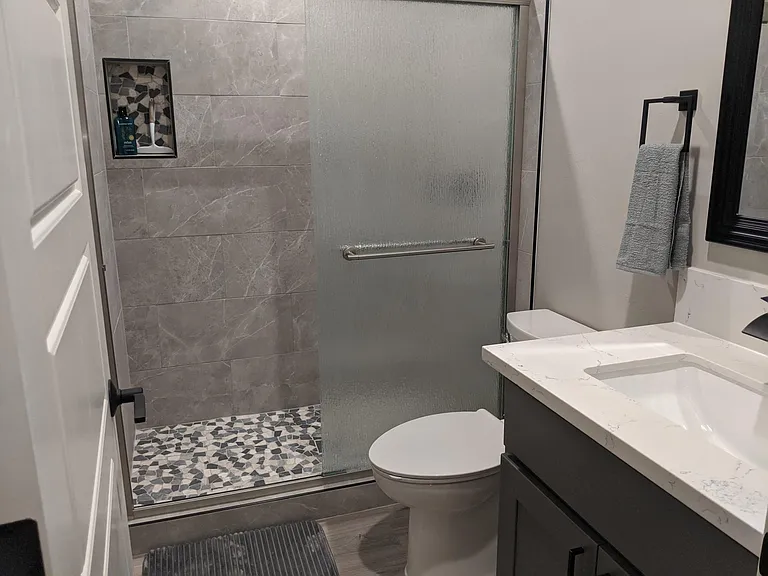 Hallway full bath with tile shower