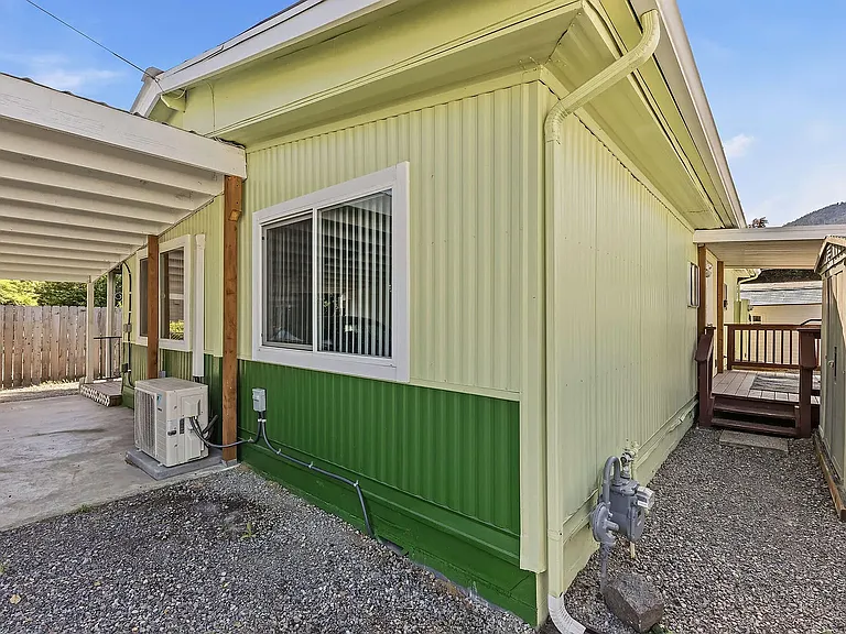 closer look at the mini-split outside unit. Walk way to enter back door and patio