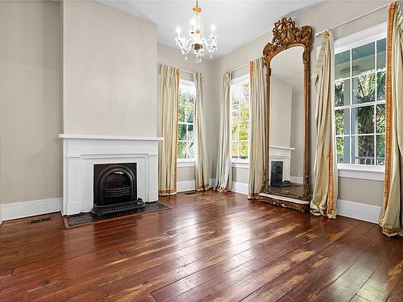 Unfurnished living room featuring a notable chandelier and dark hardwood / wood-style flooring