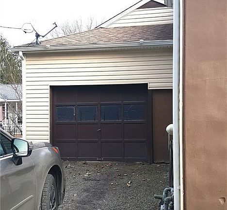 One-car attached garage has auto door opener and high ceiling with storage.