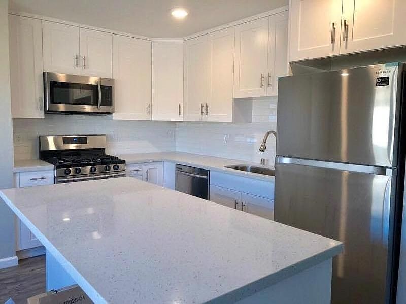 Completely updated kitchen with quartz counters, stainless steel appliances, shaker cabinets and subway tile back splash.