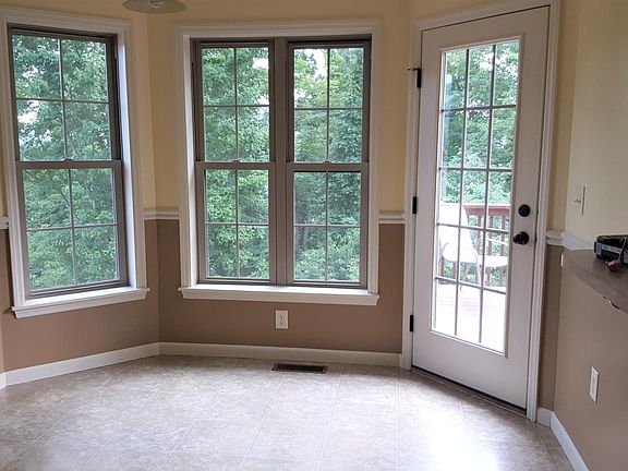 Eat-in kitchen overlooks back deck and woods