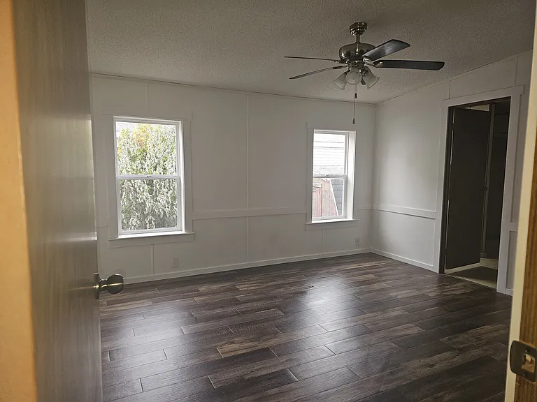 Large Master Bedroom with brand new vinyl windows, new wood vinyl plank flooring, new trim, freshly painted, and beautiful ceiling fan to keep the temperature in the room just right.
