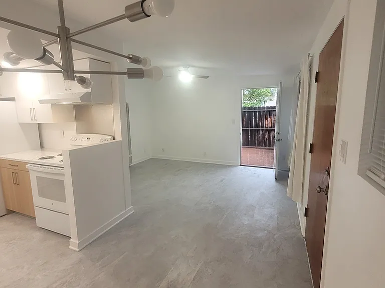 View from dining space to living room with back door to deck and private yard.