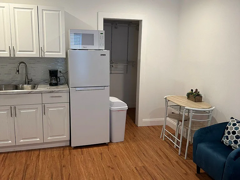 The kitchen is equipped with a refrigerator, coffee maker, and essential amenities.