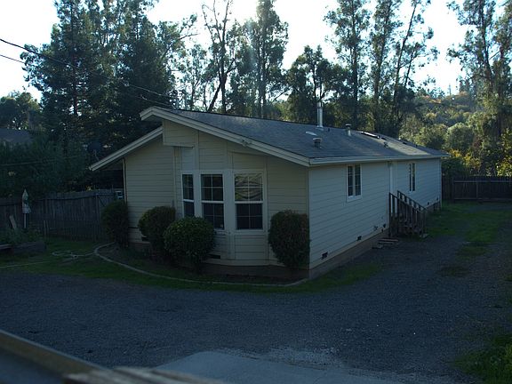 Front of the house with side entrance and parking area.