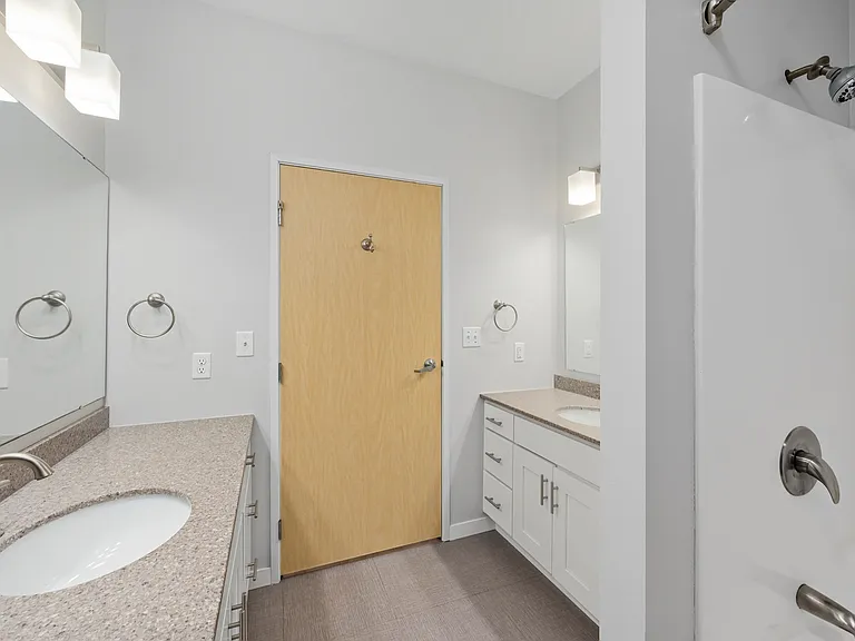 Modern bathroom with sleek countertops, dual sinks, and a spacious shower area. Modern bathroom with sleek countertops, dual sinks, and a spacious shower area.