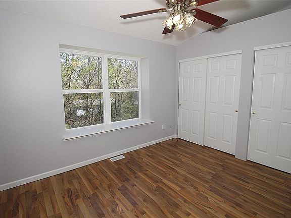 Spacious Master Bedroom with wood laminate flooring. very large bay window with wide window sill, vaulted ceiling, two double six panel sliding closet doors which have all been freshly painted.