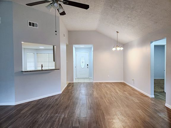 A beautiful front door with a decorative glass Texas Star and freshly painted walls welcomes you home into a spacious open concept dining room and living area.