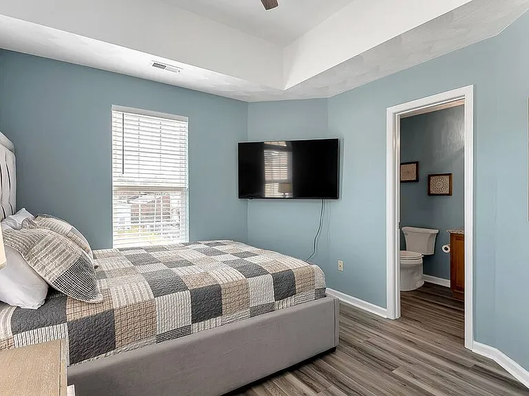 3rd floor bedroom with queen bed and attached bathroom.