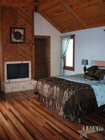Expansive first floor Master bedroom wrapped with warm wood tones