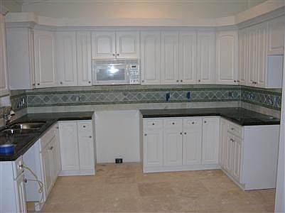 Granite and custom thumble stone backsplash make this home feel like a mansion