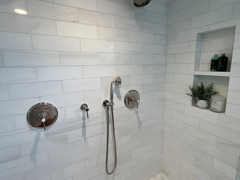 White Italian Marble imported from the Dolomite Mountains. Double Restoration Hardware showers and a convenient hand held shower and double soap / shampoo cubbies.