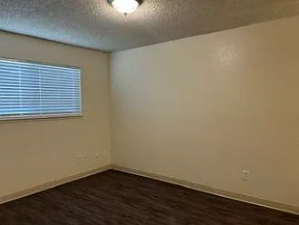 Master bedroom with new paint, vinyl plank flooring and overhead lighting