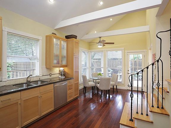 Eat-in kitchen with raised ceiling, granite counters, and stainless appliances.